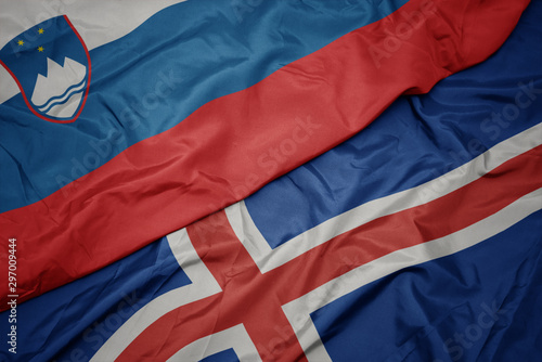 waving colorful flag of iceland and national flag of slovenia.