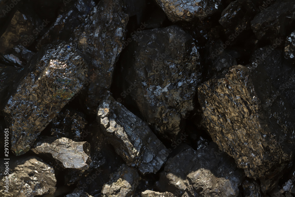 Black coal mine close-up with soft focus. Anthracite coal bar on dark background. Natural black coal bars for background. Industrial coal nuggets close up