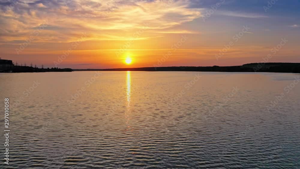 Beautiful sunset is reflecting in the river. Sunset lake landscape. Colorful sky. Nature and water.