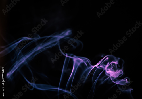 Colored blue smoke on a black background. Trendy color of the year 2022