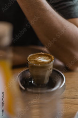 Un caf   Macchiato dans une petite tasse avec des motifs dans la mousse de lait