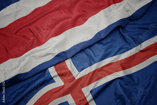 waving colorful flag of iceland and national flag of costa rica.