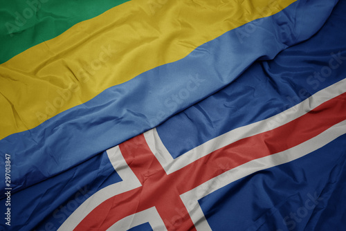 waving colorful flag of iceland and national flag of gabon.