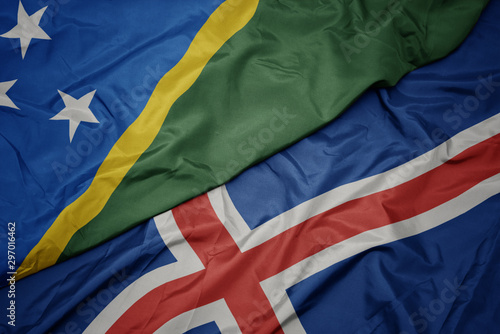waving colorful flag of iceland and national flag of Solomon Islands .