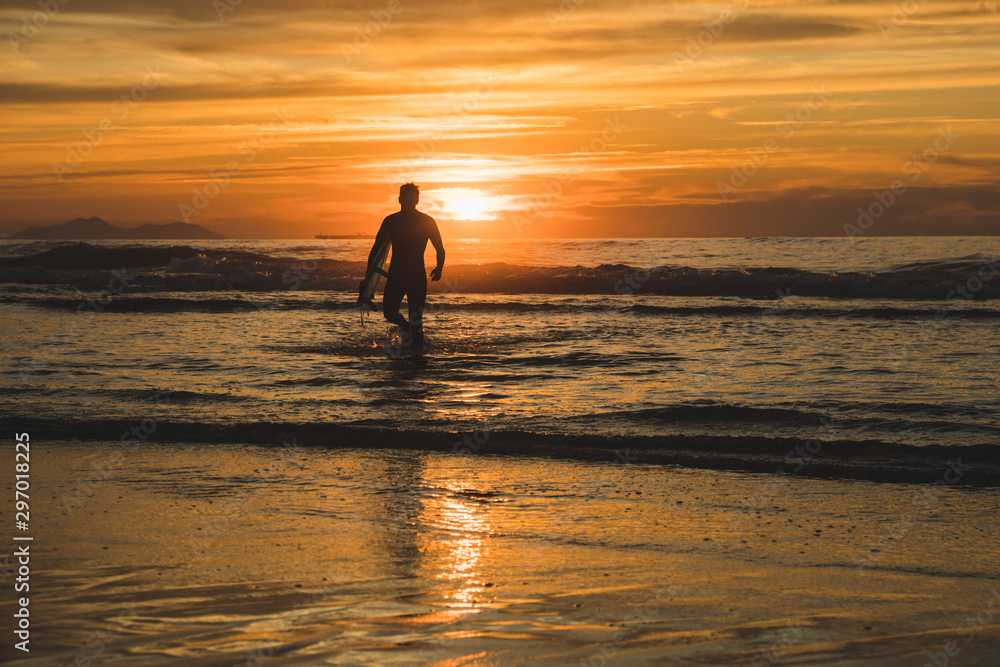 Silhouette of a surfer walking on the beach of the Atlantic Ocean, near San Sebastian and Bilbao, North of Spain Silhouette of a surfer walking on the beach of the Atlantic Ocean, near San Sebastian and Bilbao, North of Spain