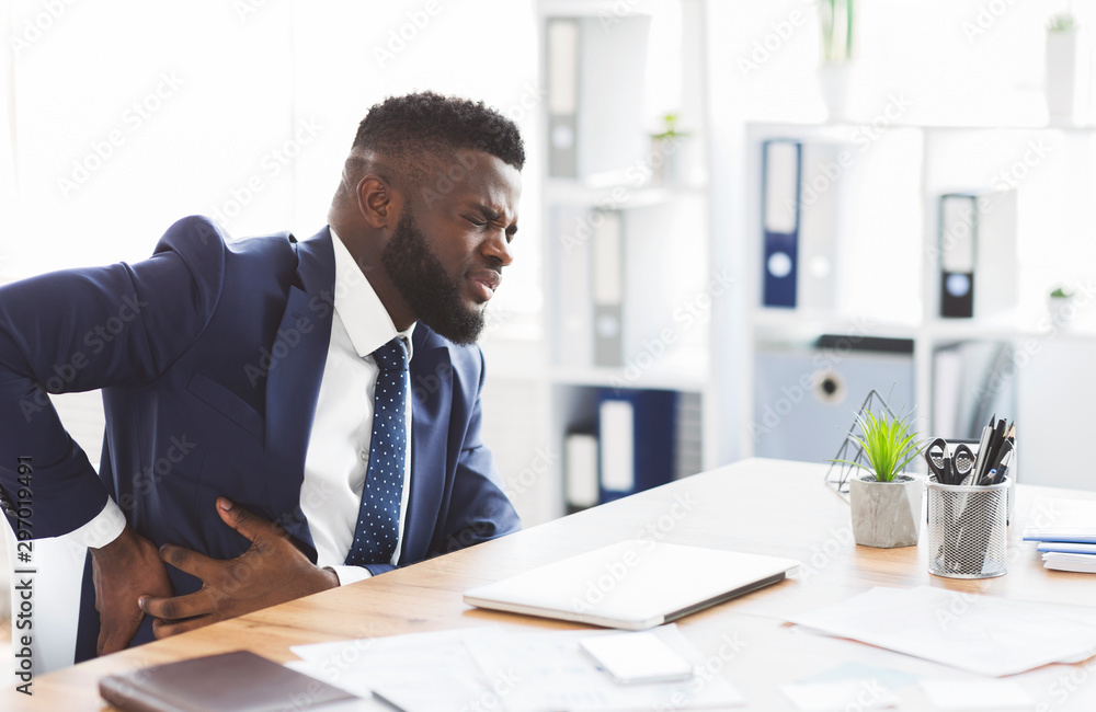 Businessman holding his side, suffering from liver pain Businessman holding his side, suffering from liver pain