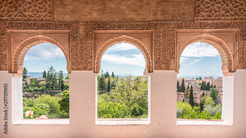 window over the heaven, tree arch windows in generalife ornate with arabic motif. alhambra. spain photo