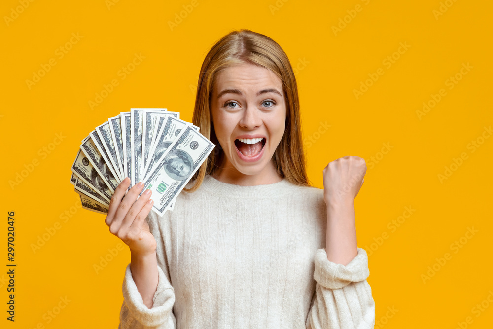 Ecstatic teen girl rejoicing success and holding lots of cash Ecstatic teen girl rejoicing success and holding lots of cash