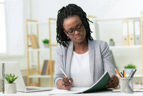 Afro Business Lady Taking Notes Working In Modern Office photo