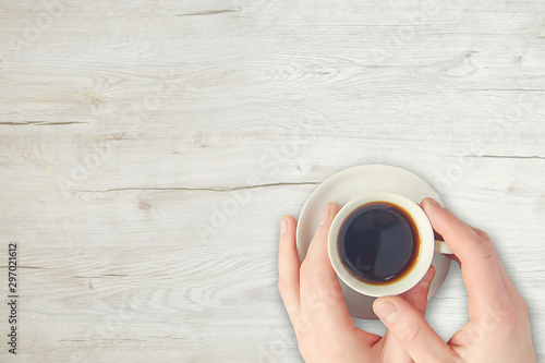 hand holding cup of coffee on blue background