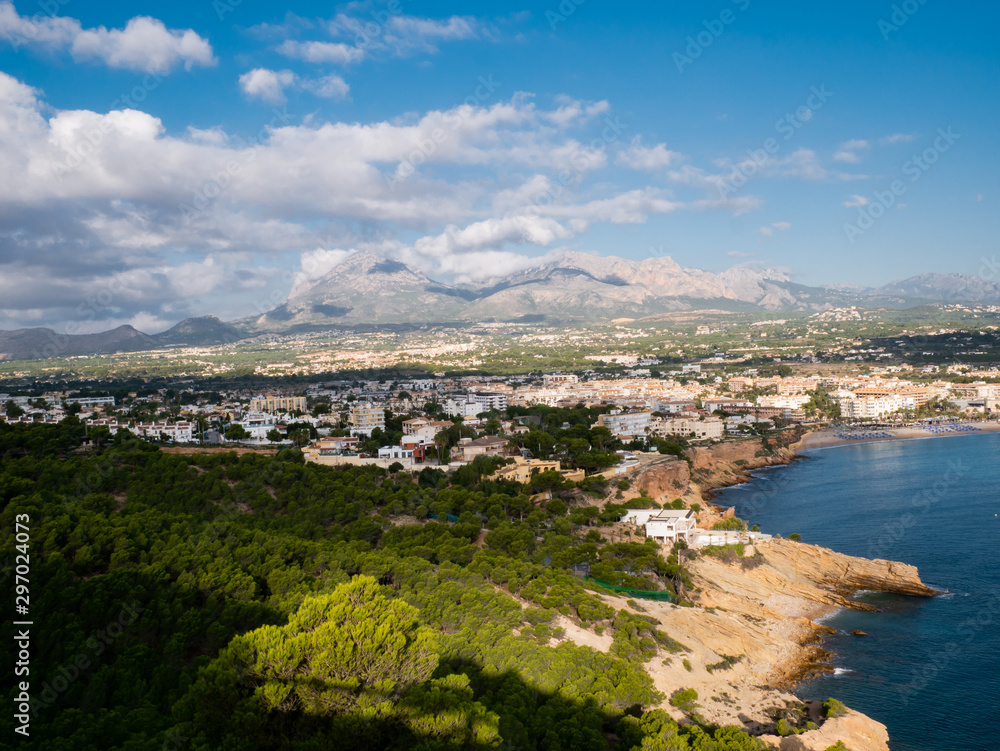 aerial view of coastal town with beach and mountains