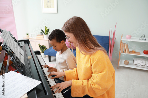 Woman teaching little Afric...