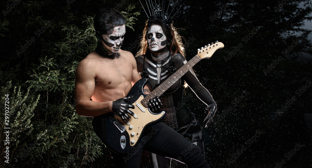 Fototapeta premium Jóvenes músicos cantando y tocando guitarra en noche de brujas en latinoamérica