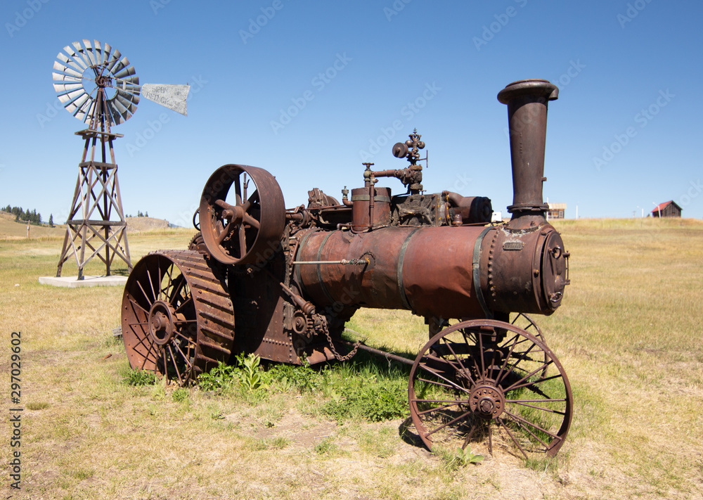 old steam powered tractor rusting way in field