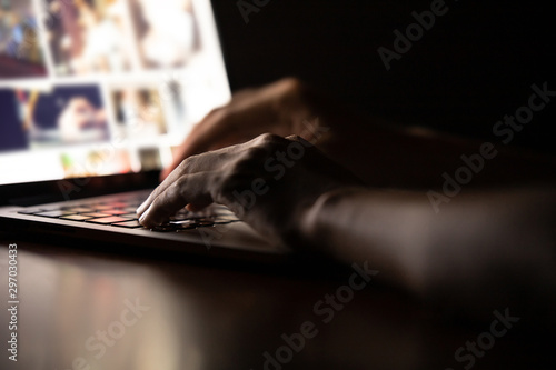 Konstfotografi Hand of a man using laptop computer for hacking or steal data at night in office