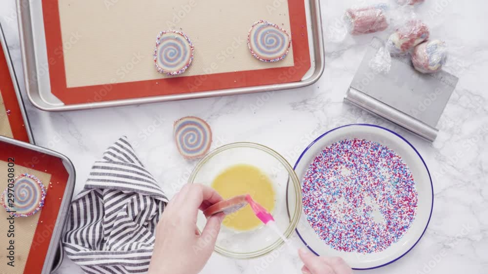 Step by step. Flat lay. Rolling edges of red, white, and blue pinwheel sugar cookies in sprinkles. Step by step. Flat lay. Rolling edges of red, white, and blue pinwheel sugar cookies in sprinkles.