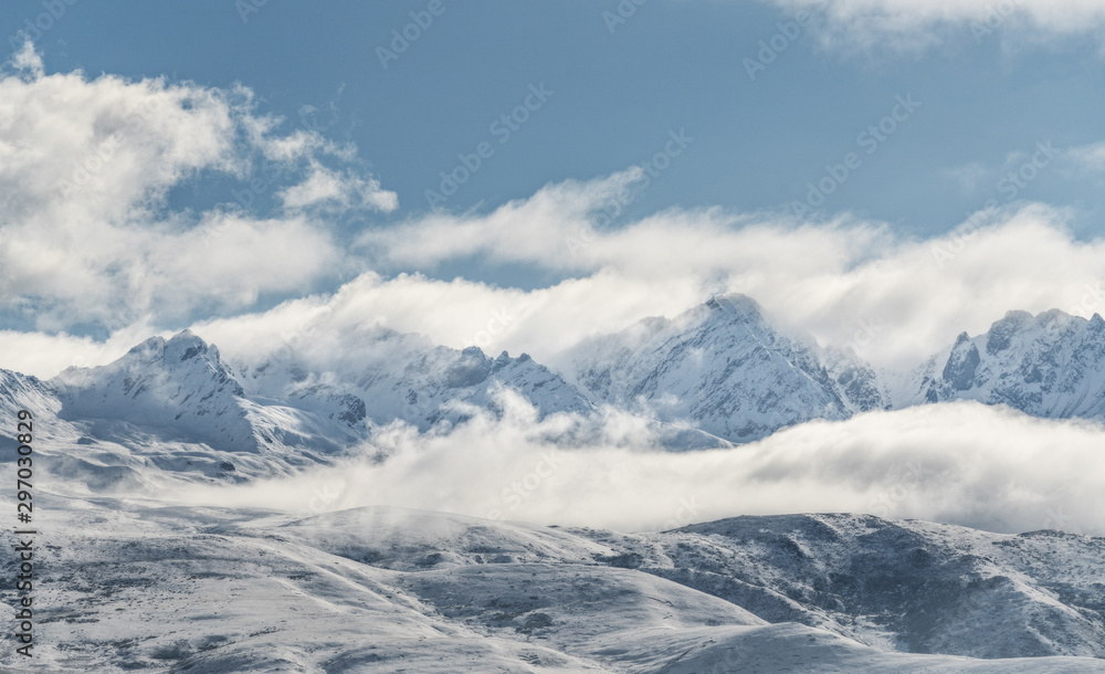 Panoramic snow mountain with white clouds and blue sky	
