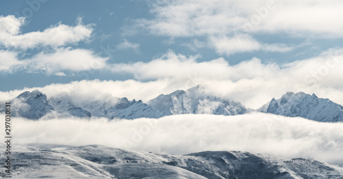 Panoramic snow mountain with white clouds and blue sky 