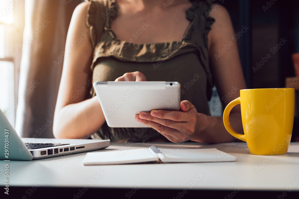 Woman using smart phone for mobile payments online shopping,omni channel,sitting on table,virtual icons graphics interface screen in morning light Woman using smart phone for mobile payments online shopping,omni channel,sitting on table,virtual icons graphics interface screen in morning light