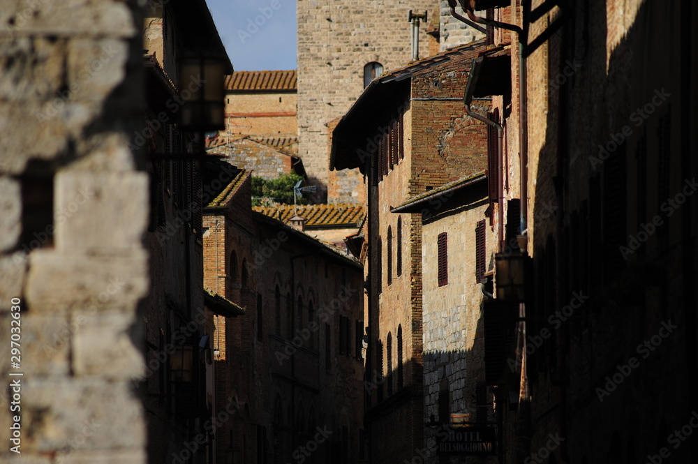 Le strade di San Gimignano, un vicolo medievale con torre di sfondo Le strade di San Gimignano, un vicolo medievale con torre di sfondo