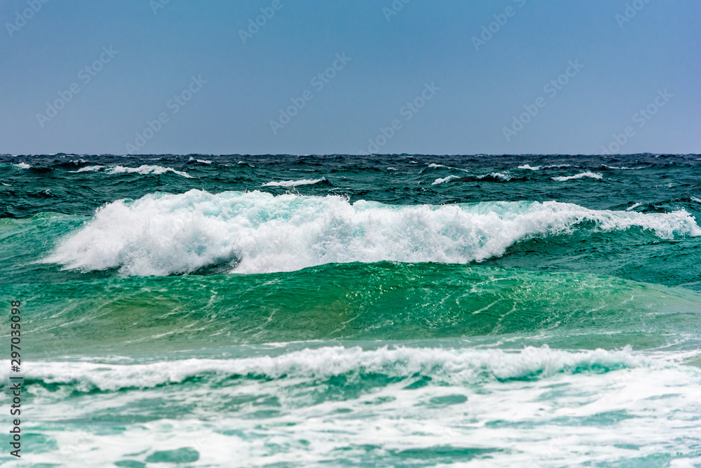 Turquoise colour ocean wave in windy day.