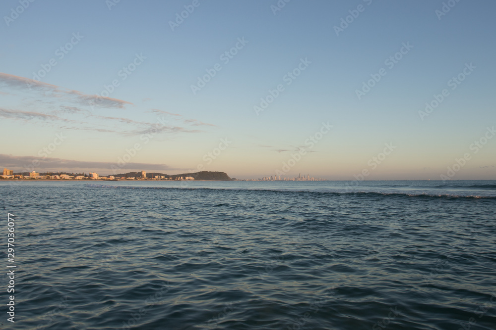 View From A Fishing Boat With Blue Water At Sunrise Towards Gold Coast City And Burleigh Headland With Orange Sky View From A Fishing Boat With Blue Water At Sunrise Towards Gold Coast City And Burleigh Headland With Orange Sky