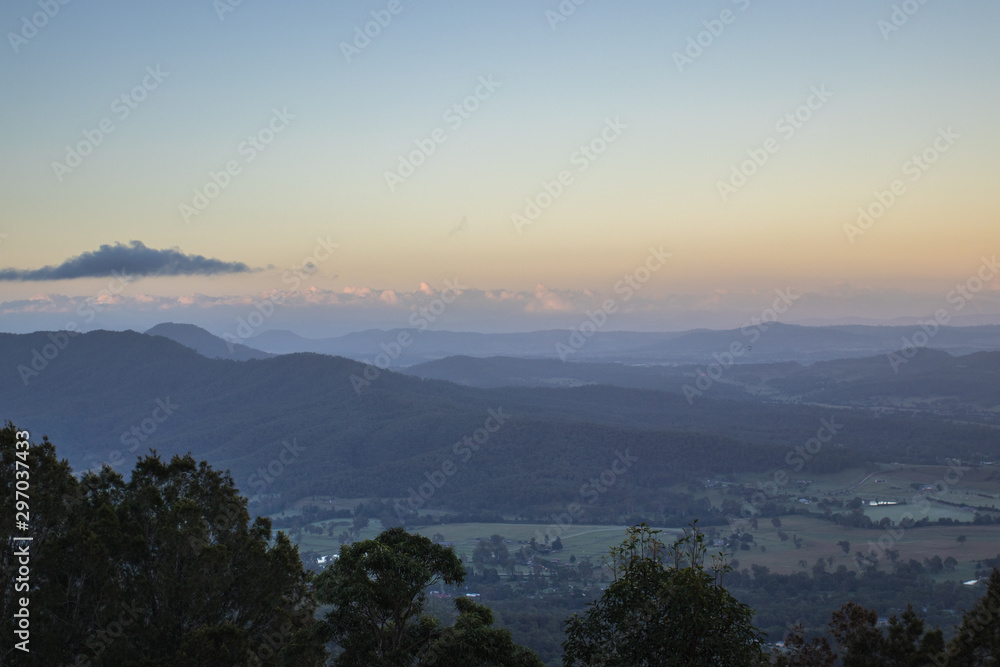 View From A Lookout Above Rural Farmlands In Australia At Sunrise With Misty Blue Skies