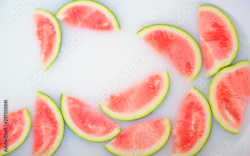 Turbid soapy water in bath with slices of watermelon. top view in full frame. The largest berry. spa with milk in the bath for rejuvenation..