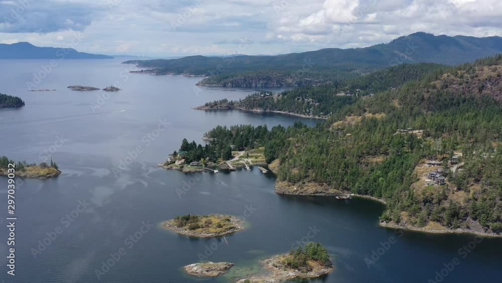 Aerial view over inlet, ocean and island with boat and mountains in beautiful British Columbia. Canada. 4K. Aerial view over inlet, ocean and island with boat and mountains in beautiful British Columbia. Canada. 4K.