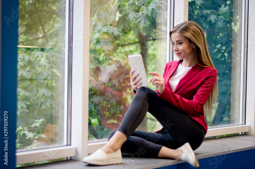 Free Download Portrait of a beautiful girl in a suit and a tablet in her hands. The concept of development and training. - GFXLoad