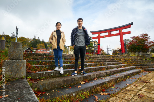Asian man and woman are traveling at Chuzenji Lake, Nikko, Toshiba, Japan, in autumn. photo