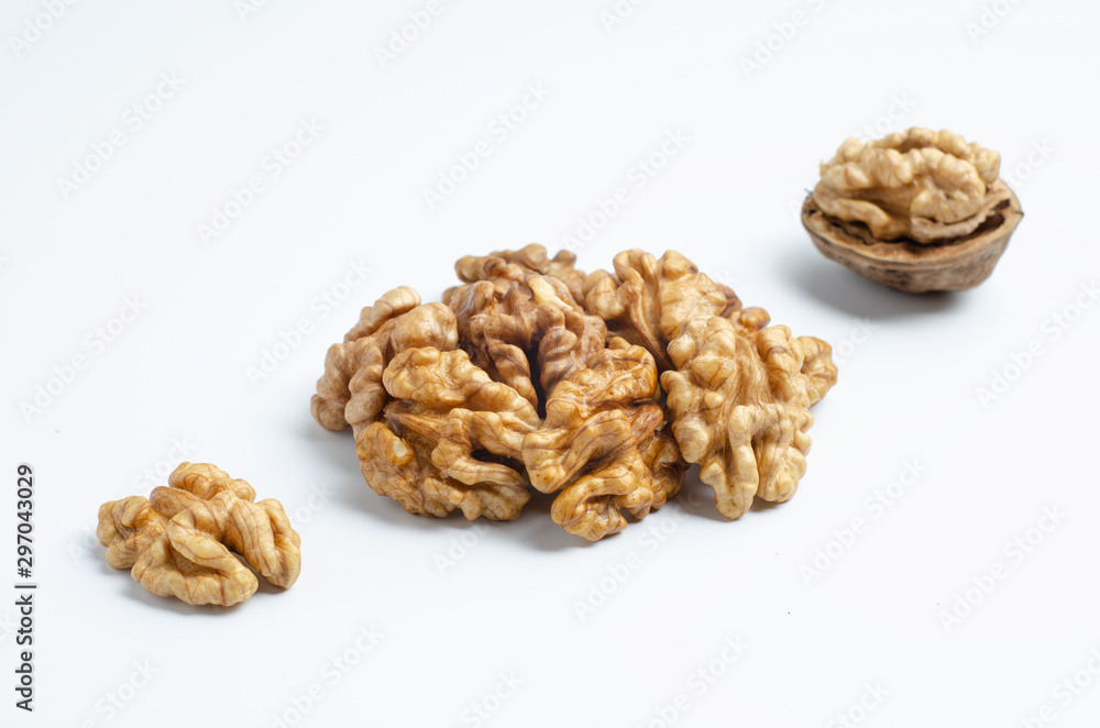 Three walnuts lying in a diagonal line, a closed walnut, half peeled walnut and half a walnut. Three walnuts lying in a diagonal line, a closed walnut, half peeled walnut and half a walnut.