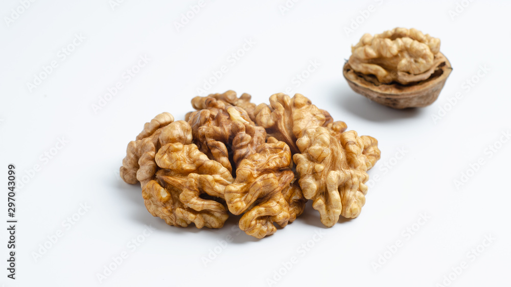 Handful of walnuts and half peeled walnut on an isolated background Handful of walnuts and half peeled walnut on an isolated background