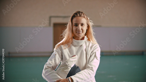 Foto Young fencer is holding in hands a helmet and looking at the camera