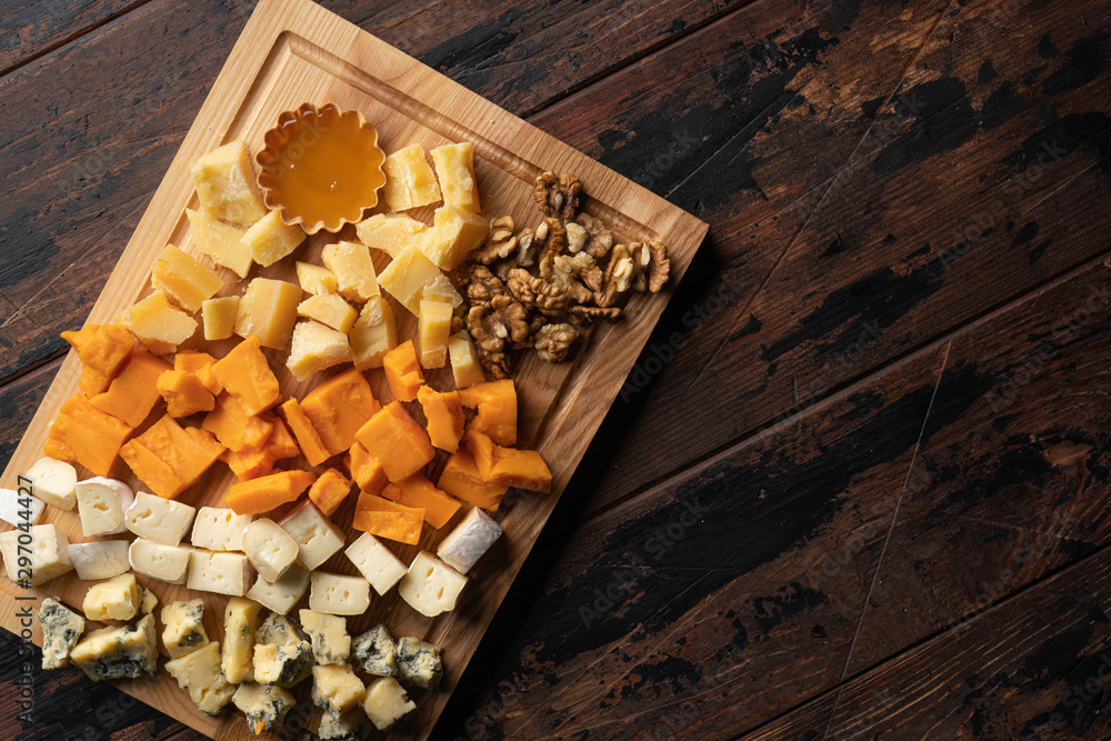 various cheeses with honey on the wooden board various cheeses with honey on the wooden board