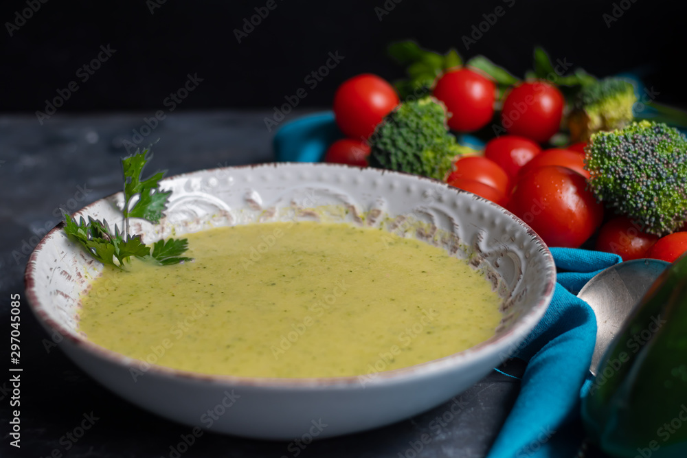 Detox green broccoli cream soup with chia seeds, red onions, green peppers, cherry tomatoes and croutons on a gray background. Healthy eating concept. Copy space. Detox green broccoli cream soup with chia seeds, red onions, green peppers, cherry tomatoes and croutons on a gray background. Healthy eating concept. Copy space.