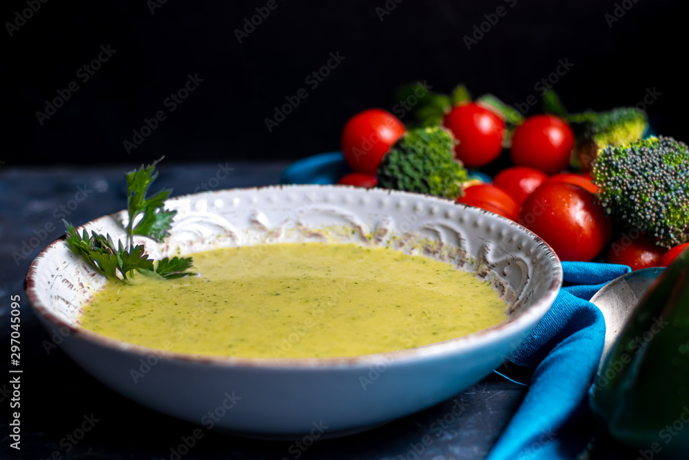 Detox green broccoli cream soup with chia seeds, red onions, green peppers, cherry tomatoes and croutons on a gray background. Healthy eating concept. Copy space. Detox green broccoli cream soup with chia seeds, red onions, green peppers, cherry tomatoes and croutons on a gray background. Healthy eating concept. Copy space.