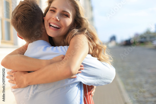Beautiful young couple in love walking outdoors at the city street, hugging