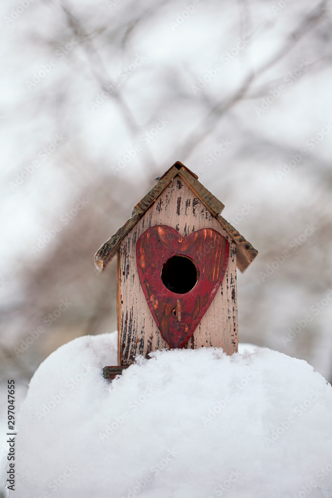 Fototapeta premium Cut Bird House With Heart In Snow