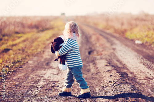 a child with a toy in his hands in the rays of the setting sun