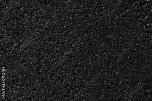 Wet asphalt texture, material. Black backdrop, grain pavement. Dark grunge surface, background.