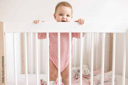 Baby girl standing in bed  