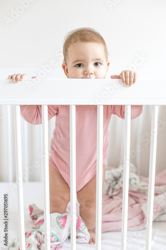 Baby girl standing in bed  