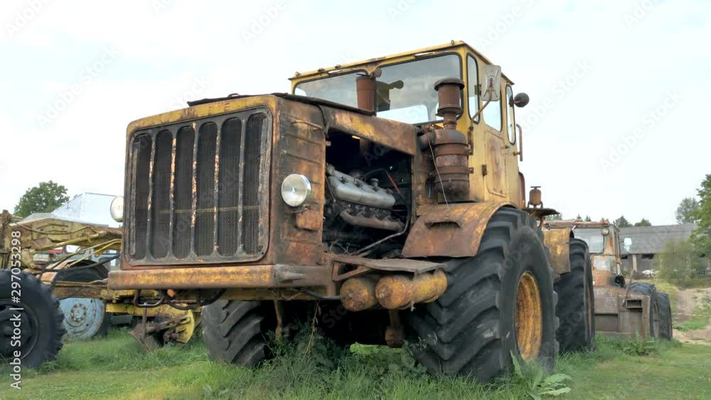 The yellow rusty old bulldozer on the side of the garage The yellow rusty old bulldozer on the side of the garage