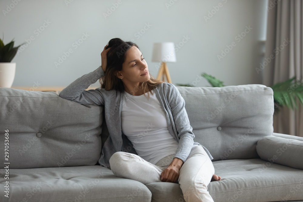 Peaceful thoughtful young mixed race woman sitting on cozy sofa. Peaceful thoughtful young mixed race woman sitting on cozy sofa.