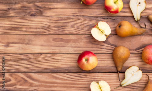 Apples with pears on the wooden background. Top view. Space for text.