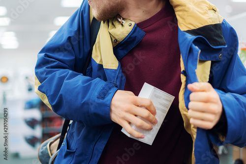 Fotografi close up consumer  thief’s hands putting the new gadget in the pocket in the sto