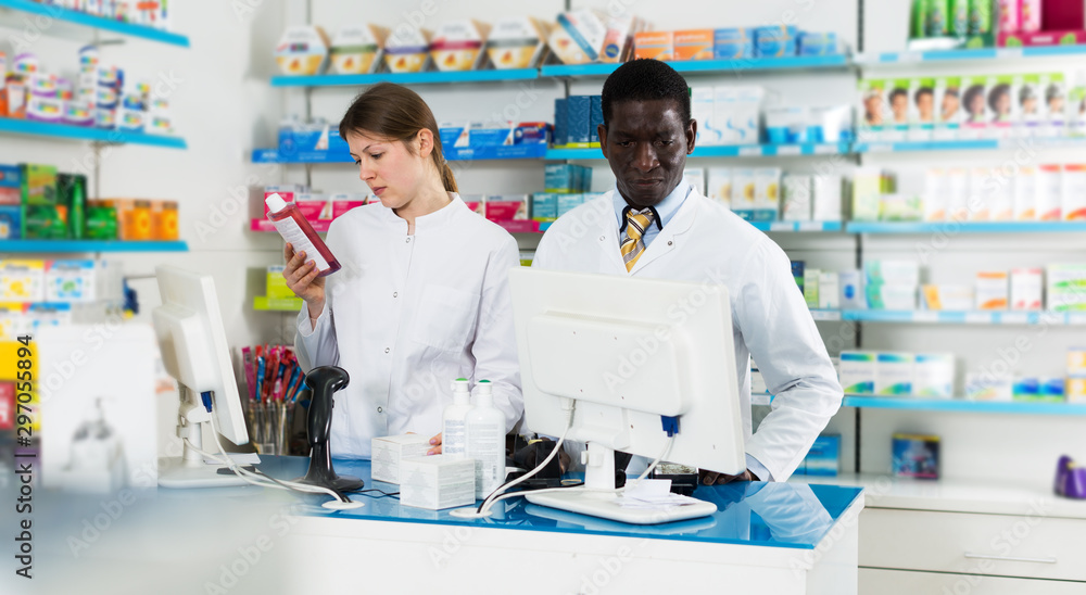 Two pharmacists working behind counter