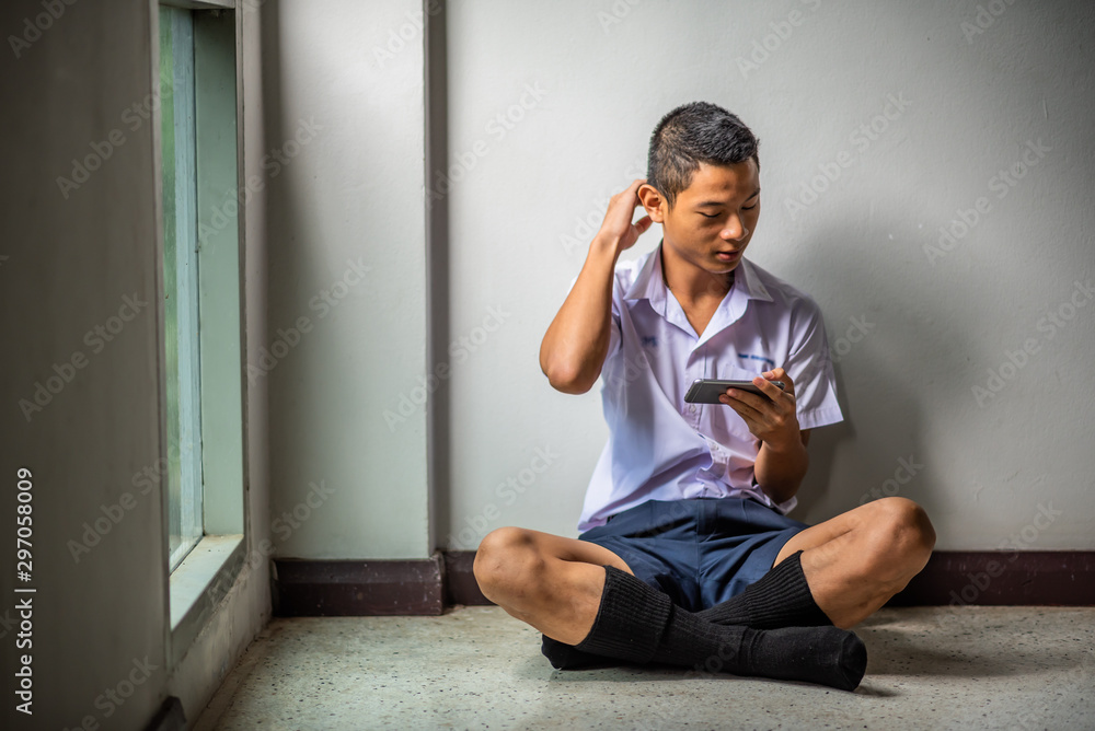 Male Asian high school student in white uniform addicted to online ...