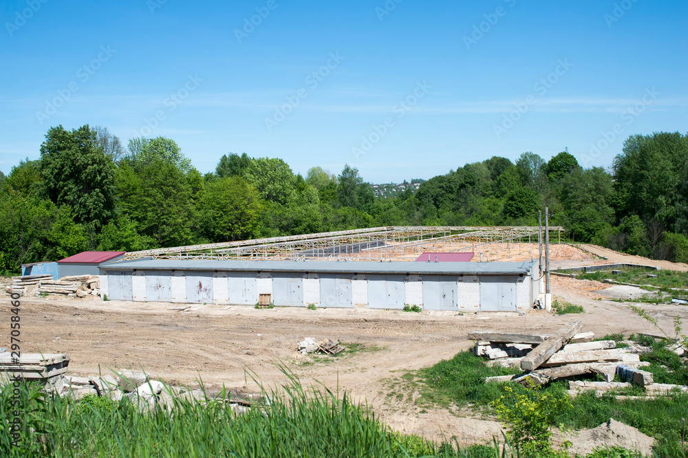Construction of garages in the cleared area among the forest. The concept of imbalance of industry and ecology
